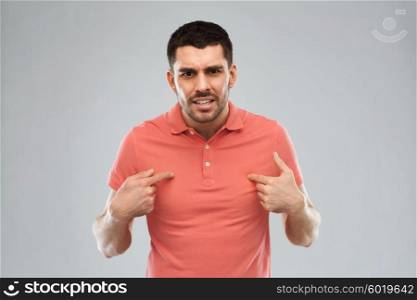 emotion, gesture, argue and people concept - arguing angry man pointing finger to himself over gray