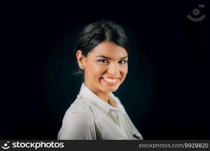 Emotion Happiness. Face of a beautiful happy young woman smiling, studio portrait, black background