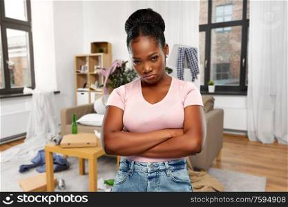 emotion, mess and people concept - angry african american woman with crossed arms over dirty room background. angry african american woman over dirty room