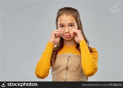 emotion, sadness and people concept - unhappy crying teenage girl over gray background. unhappy crying teenage girl over gray background