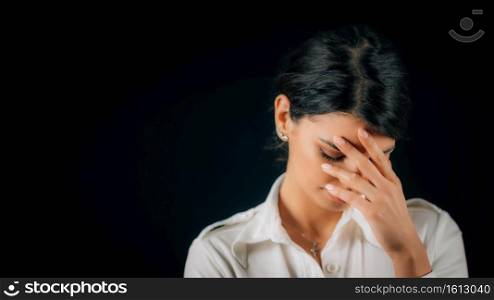 Emotion Shame. Face of a beautiful shameful young woman, expressing shame, studio portrait, black background