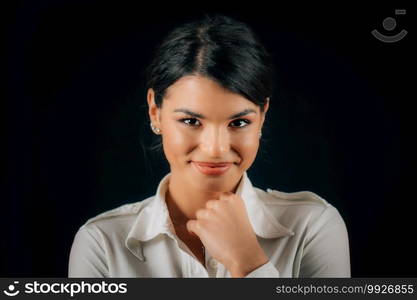 Emotion Shyness. Face of a beautiful shy young woman, expressing shyness, studio portrait, black background