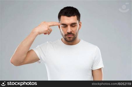 emotion, stress and people concept - man making finger gun gesture over gray background