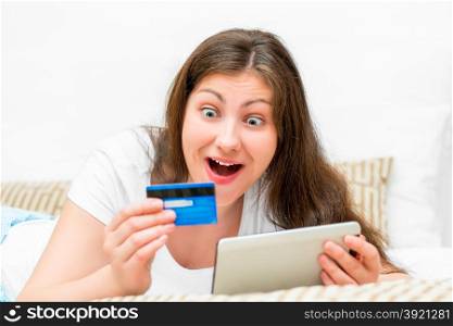 emotional brunette with credit card and tablet computers
