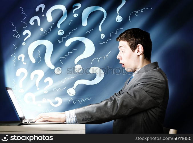 Emotional man using laptop. Young man looking in laptop screen with shock