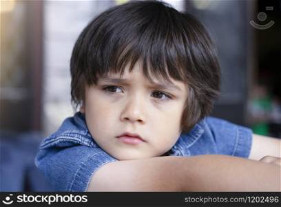 Emotional portrait of Unhappy Toddler boy with sad face, Upset boy standing alone looking out with deep in thought Kid sad face looking down, Lonely kid with bored face, Spoiled children