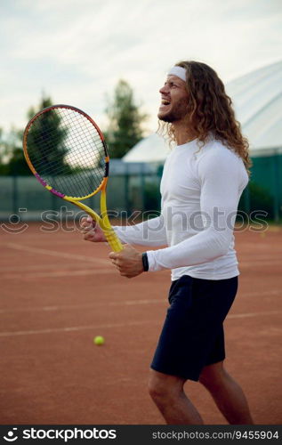 Emotional professional tennis player celebrating win clenching fists. Professional sportsman showing winner facial expression feeling excitement after win in highly tensioned game. Emotional professional tennis player celebrating win clenching fists