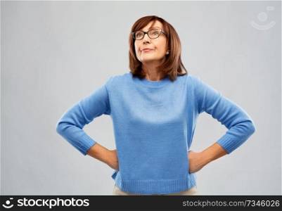 emotions and old people concept - displeased senior woman in glasses over grey background. displeased senior woman in glasses over grey