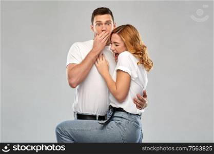 emotions and people concept - scared couple in white t-shirts over grey background. scared couple in white t-shirts