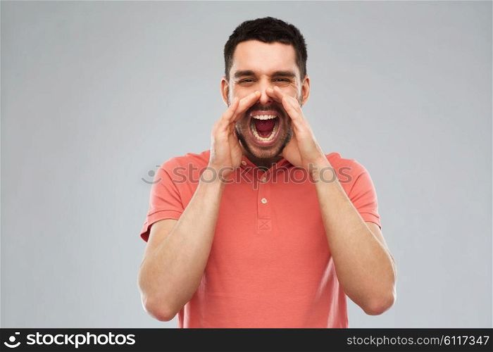 emotions, communication and people concept - angry shouting man in t-shirt over gray background