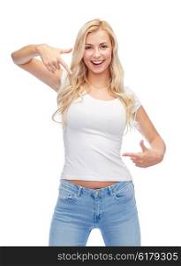 emotions, expressions, advertisement and people concept - happy smiling young woman or teenage girl in white t-shirt pointing finger to herself