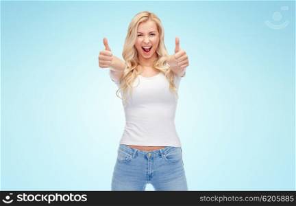 emotions, expressions, advertisement and people concept - happy smiling young woman or teenage girl in white t-shirt showing thumbs up with both hands over blue background