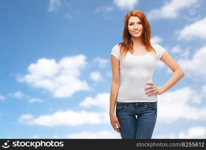 emotions, expressions, advertisement and people concept - happy smiling young woman or teenage girl in white t-shirt over blue sky and clouds background