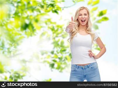 emotions, expressions, advertisement, summer and people concept - happy smiling young woman or teenage girl in white t-shirt showing thumbs up over green natural background
