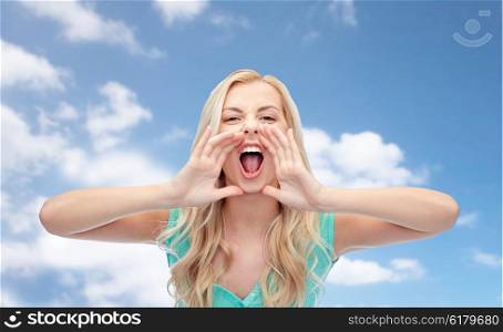 emotions, expressions and people concept - angry young woman or teenage girl shouting over blue sky and clouds background