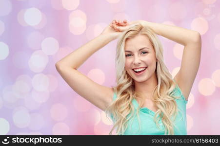 emotions, expressions and people concept - happy smiling young woman or teenage girl over pink holidays lights background