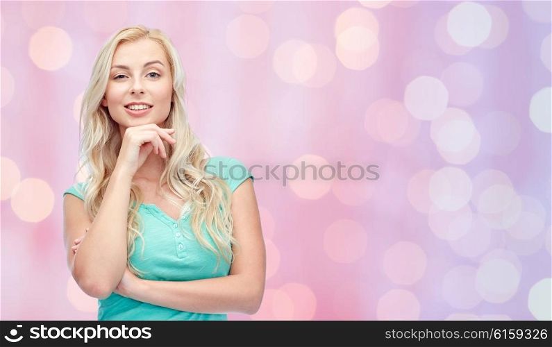 emotions, expressions and people concept - happy smiling young woman or teenage girl over pink holidays lights background