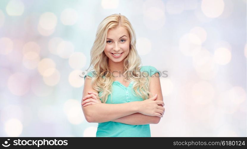 emotions, expressions and people concept - happy smiling young woman or teenage girl over holidays lights background