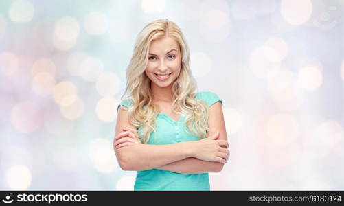 emotions, expressions and people concept - happy smiling young woman or teenage girl over holidays lights background