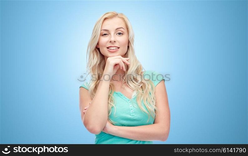 emotions, expressions and people concept - happy smiling young woman or teenage girl over blue background