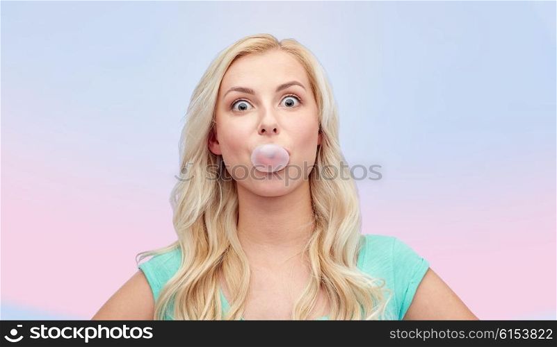 emotions, expressions and people concept - happy young woman or teenage girl chewing gum over rose quartz and serenity gradient background