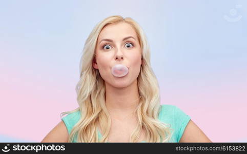 emotions, expressions and people concept - happy young woman or teenage girl chewing gum over rose quartz and serenity gradient background