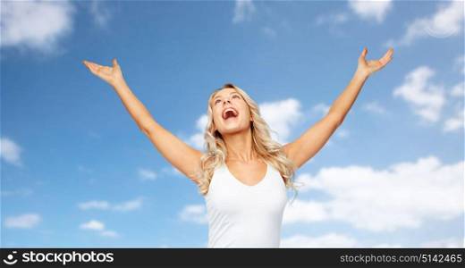 emotions, expressions and people concept - happy young woman with raised hands celebrating victory over blue sky and clouds background. happy woman celebrating victory over blue sky