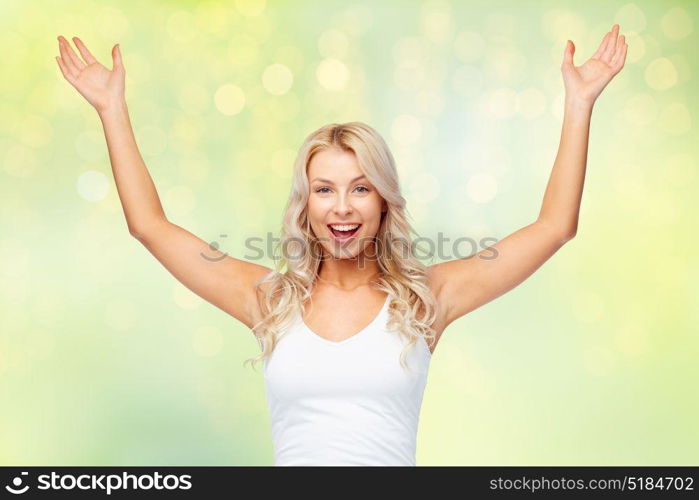 emotions, expressions and people concept - happy young woman with raised hands celebrating victory over summer green lights background. happy young woman celebrating victory