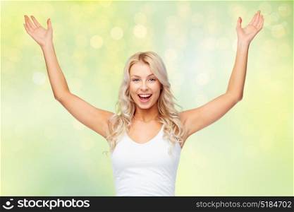 emotions, expressions and people concept - happy young woman with raised hands celebrating victory over summer green lights background. happy young woman celebrating victory