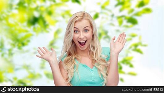 emotions, expressions and people concept - surprised smiling young woman or teenage girl over over green natural background