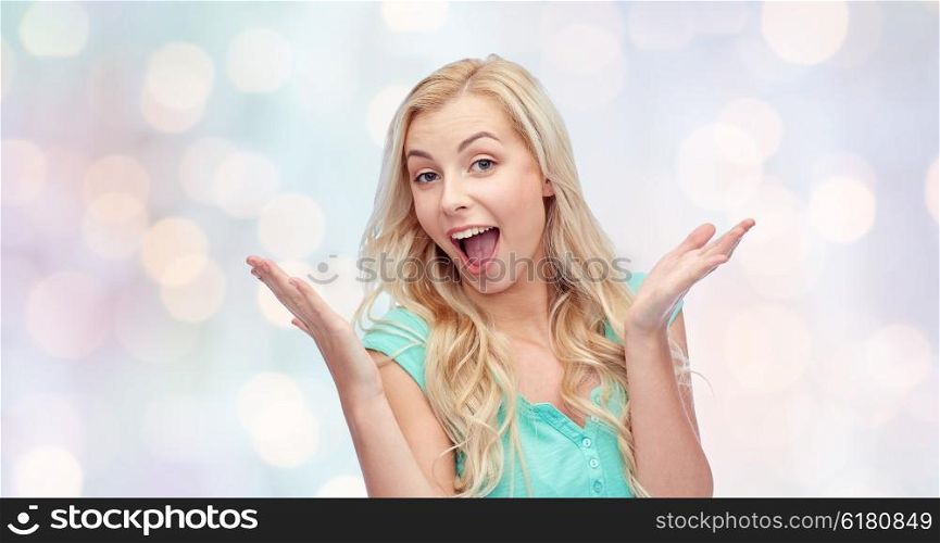 emotions, expressions and people concept - surprised smiling young woman or teenage girl over holidays lights background