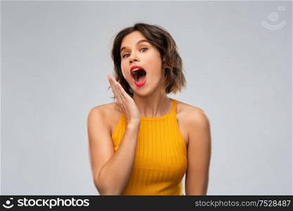 emotions, expressions and people concept - surprised young woman in mustard yellow top over grey background. surprised young woman in mustard yellow top