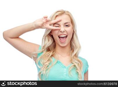 emotions, expressions, gesture and people concept - smiling young woman or teenage girl showing peace hand sign