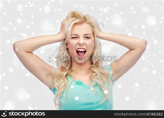 emotions, expressions, hairstyle and people concept - smiling young woman or teenage girl holding to her head or touching hair over snow