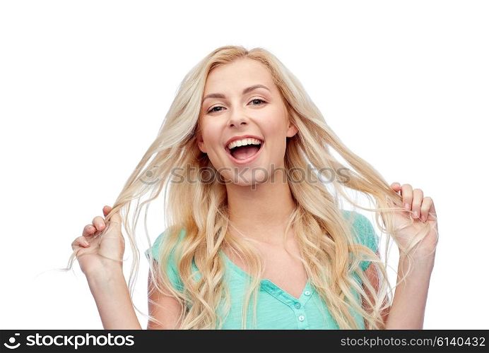 emotions, expressions, hairstyle and people concept - smiling young woman or teenage girl holding her strand of hair