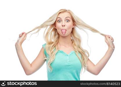 emotions, expressions, hairstyle and people concept - smiling young woman or teenage girl showing her tongue and holding strand of hair