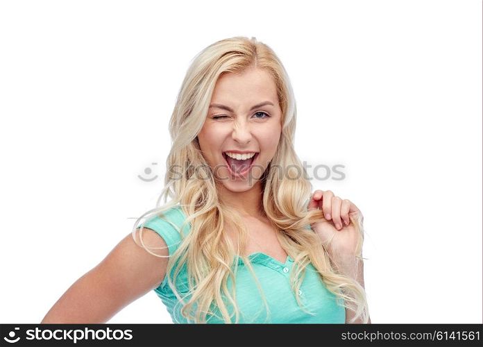 emotions, expressions, hairstyle and people concept - smiling young woman or teenage girl holding her strand of hair and winking