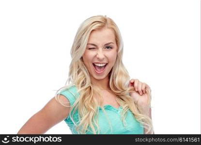 emotions, expressions, hairstyle and people concept - smiling young woman or teenage girl holding her strand of hair and winking