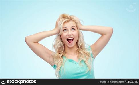 emotions, expressions, hairstyle and people concept - smiling young woman or teenage girl holding to her head or touching hair over blue background