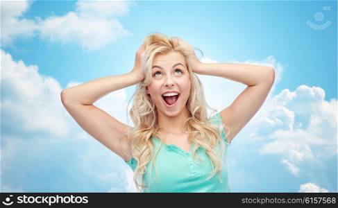 emotions, expressions, hairstyle and people concept - smiling young woman or teenage girl holding to her head or touching hair over blue sky and clouds background