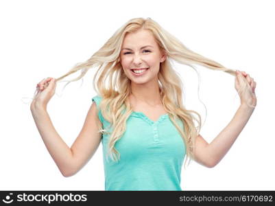 emotions, expressions, hairstyle and people concept - smiling young woman or teenage girl holding strands of her hair