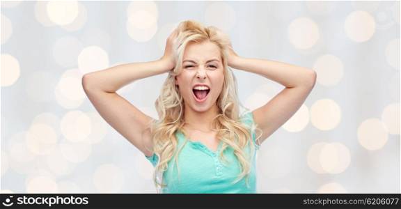 emotions, expressions, hairstyle and people concept - smiling young woman or teenage girl holding to her head or touching hair over holidays lights background