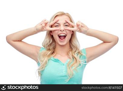 emotions, expressions, positive gesture and people concept - smiling young woman or teenage girl showing peace hand sign with both hands