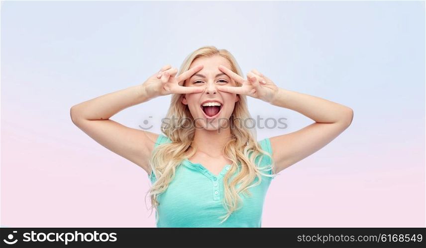 emotions, expressions, positive gesture and people concept - smiling young woman or teenage girl showing peace hand sign with both hands over rose quartz and serenity gradient background