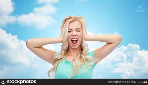 emotions, expressions, stress and people concept - young woman holding to her head and screaming over blue sky and clouds background