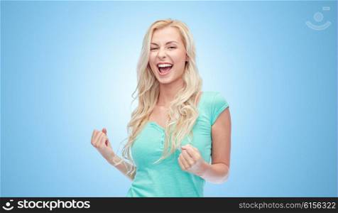 emotions, expressions, success and people concept - happy young woman or teenage girl celebrating victory over blue background