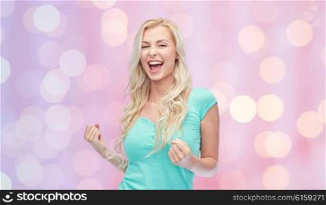 emotions, expressions, success and people concept - happy young woman or teenage girl celebrating victory over pink holidays lights background