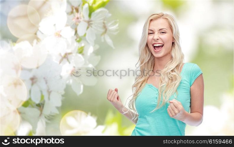 emotions, expressions, success and people concept - happy young woman or teenage girl celebrating victory over natural spring cherry blossom background