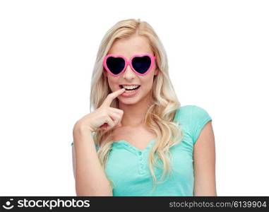 emotions, expressions, summer and people concept - smiling young woman or teenage girl in heart shape sunglasses