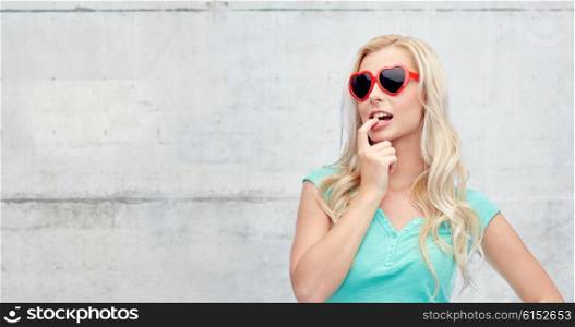 emotions, expressions, summer and people concept - smiling young woman or teenage girl in sunglasses over gray concrete wall background